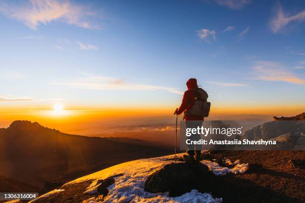 un excursionista logró el sueño disfrutando del asombro del amanecer desde lo alto de la montaña del kilimanjaro - tanzania fotografías e imágenes de stock