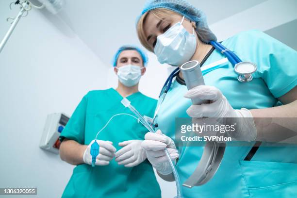el doctor tiene un laringoscopio en sus manos. - intubation fotografías e imágenes de stock