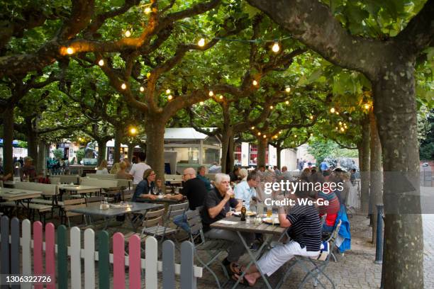 biergarten unter kochbananen auf dem burgplatz in der düsseldorfer altstadt. - biergarten stock-fotos und bilder