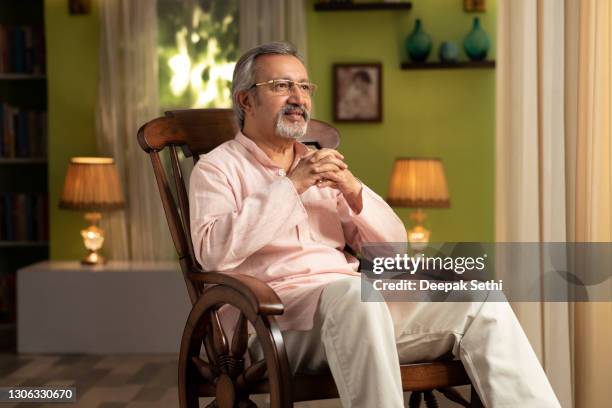 shot of a mature man sitting on rocking chair at home:- stock photo - rocking chair stock pictures, royalty-free photos & images