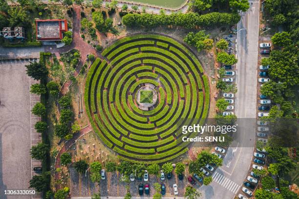 aerial view of a circular garden maze and green pavilion - maze stock-fotos und bilder