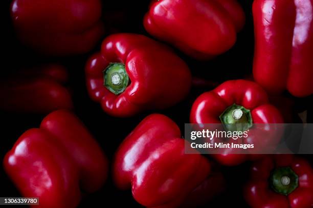 high angle close up of freshly picked red peppers. - peperone rosso foto e immagini stock
