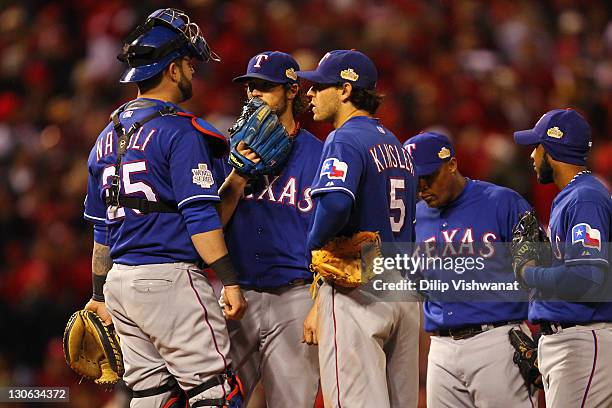 Mike Napoli, C.J. Wilson and Ian Kinsler of the Texas Rangers talk on the mound against the St. Louis Cardinals during Game One of the MLB World...