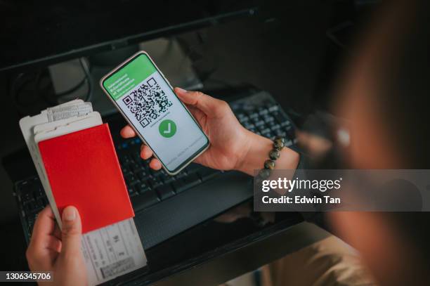 asiatische chinesische mann mit seinem nationalen pass, flugtickets und mobile app impfpass für reisen - impfpass reisedokument stock-fotos und bilder