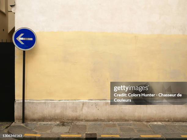 empty street with sidewalk, road sign and weathered wall in the marais district of paris - european outdoor urban walls stockfoto's en -beelden