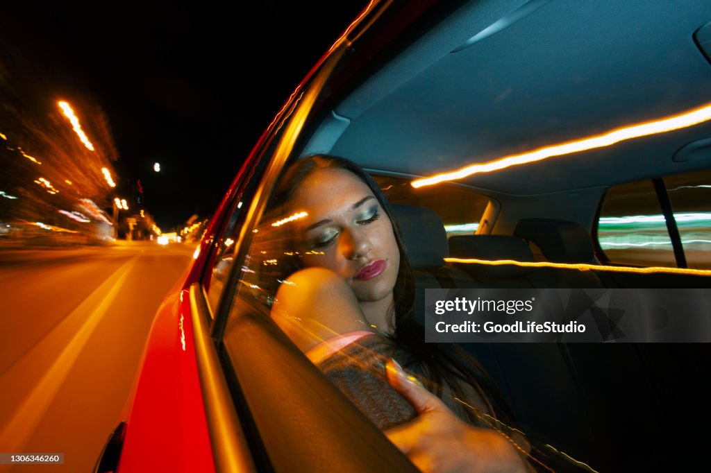 Ung kvinna sover i en taxi