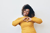 Happy African-American woman making heart with hands