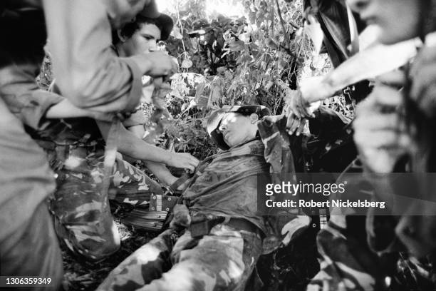 View of wounded soldier , part of the Atlacatl Battalion, as he is prepared for evacuation by other soldiers, Tenancingo, El Salvador, September 27,...