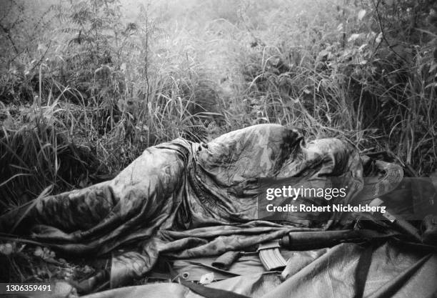 Close-up of a Salvadoran Army soldiers, from the Atlacatl Battalion, as he sleeps under a camouflage blanket on a fog-enveloped hill, San Miguel...