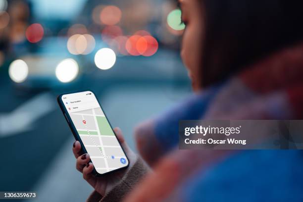 woman using gps navigation app on smartphone to navigate and look for direction in city - navegación fotografías e imágenes de stock