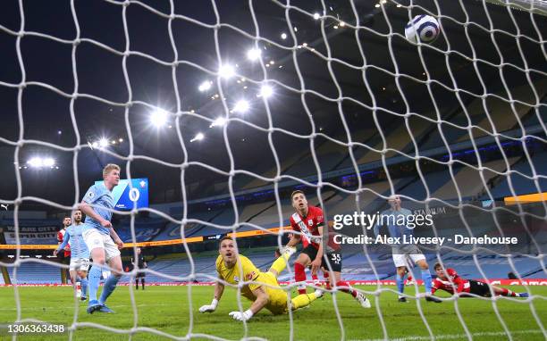 Kevin De Bruyne of Manchester City scores the opening goal past Alex McCarthy of Southampton during the Premier League match between Manchester City...