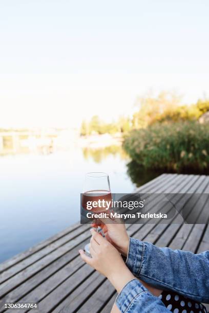 a glass of wine in a female hand on the background of nature. - wine glass finger food stock-fotos und bilder