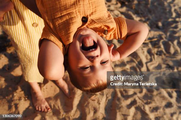 funny portrait of toddler boy showing tongue. - life event stockfoto's en -beelden