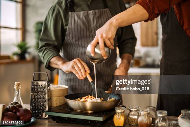 jonge mens die kookvaardigheden van een ervaren chef-kok leert. - room stockfoto's en -beelden