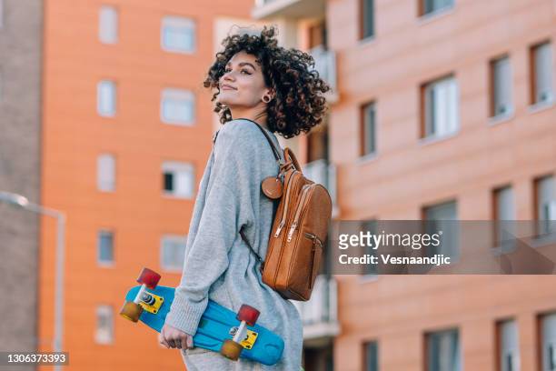 young woman with skateboard in the city - fashionable teen stock pictures, royalty-free photos & images