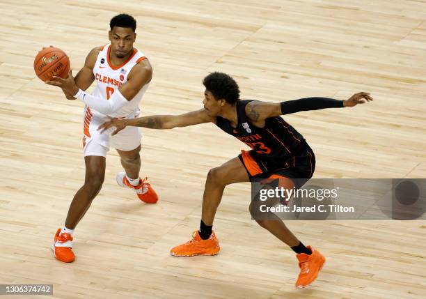 Clyde Trapp of the Clemson Tigers looks to pass against Kameron McGusty of the Miami Hurricanes during the first half of their second round game in...