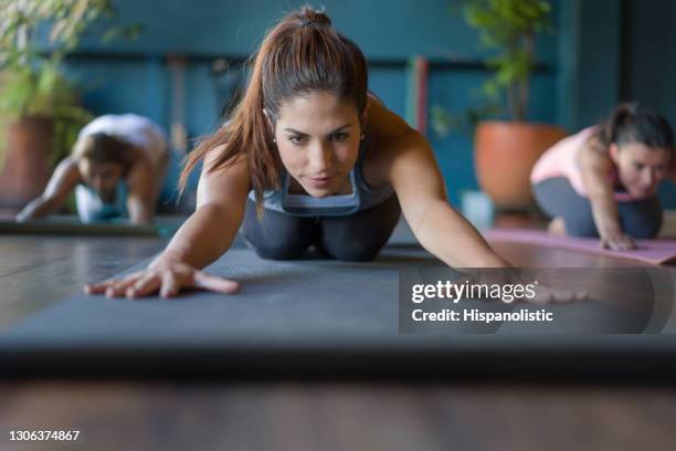 vrouwen die zich in een yogales bij een studio uitrekken - back stretch stockfoto's en -beelden