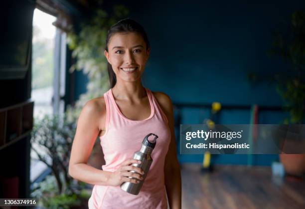 happy woman at the gym holding a water bottle - gym reopening stock pictures, royalty-free photos & images