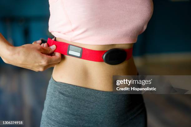 close-up op een vrouw bij de gymnastiek die op een geschiktheidstracker zet - hartmonitor stockfoto's en -beelden