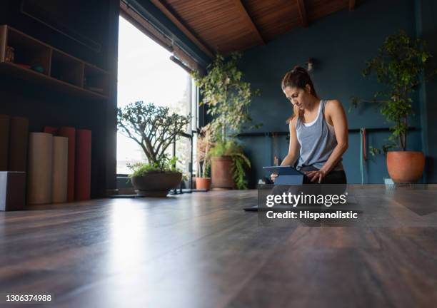 woman setting up a tablet to stream an online yoga class - life coach stock pictures, royalty-free photos & images