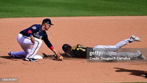 Joe Hudson of the Pittsburgh Pirates slides safely into second base under the glove of Ryan Goins of the Atlanta Braves during the seventh inning of...