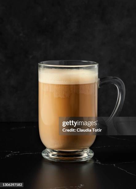 cup of chai latte on black background - ginger glasses stock-fotos und bilder