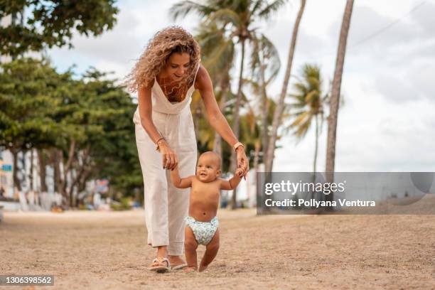 abuela enseña a bebé nieto a caminar - mothers day beach fotografías e imágenes de stock