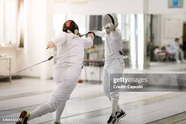 männliche fechtsportler spielen - fechtsport stock-fotos und bilder