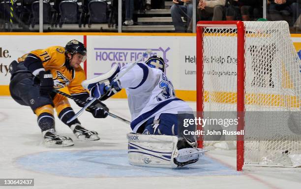 Sergei Kostitsyn of the Nashville Predators puts the puck in the net against goalie Mathieu Garon of the Tampa Bay Lightning during an NHL game on...