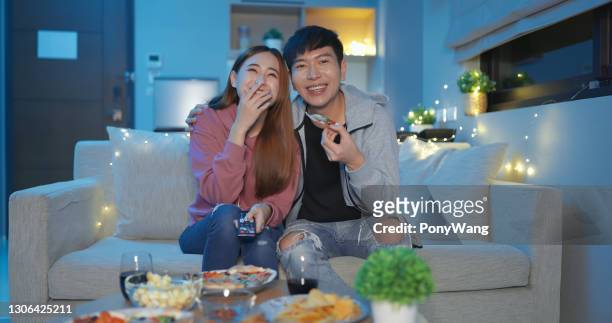 pareja asiática ve la televisión felizmente - lovers 2020 film fotografías e imágenes de stock