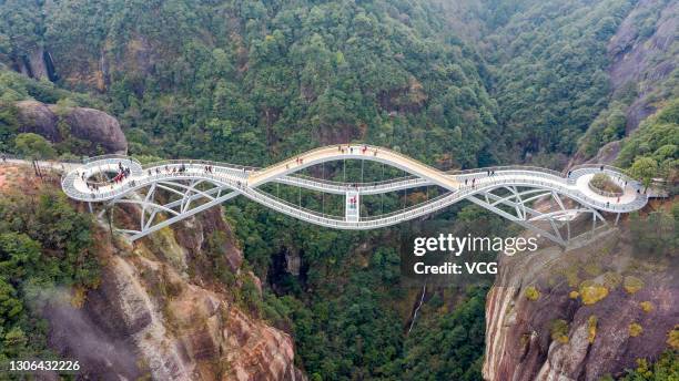 Tourists walk on Ruyi Bridge at Shenxianju Scenic Area on March 9, 2021 in Taizhou, Zhejiang Province of China.