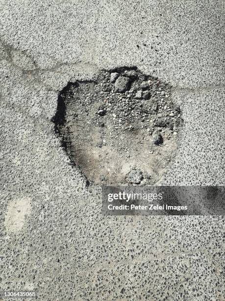 pothole on the asphalt road - pothole stockfoto's en -beelden