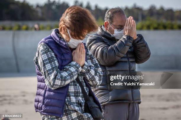 People pray for victims of the 2011 Tohoku earthquake and tsunami at a beach on March 11, 2021 in Iwaki, Japan. Japan will today observe the 10th...