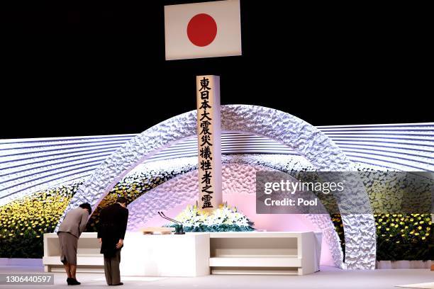 Japan's Emperor Naruhito and Empress Masako bow in front of the altar for victims of the March 11, 2011 earthquake and tsunami at the national...