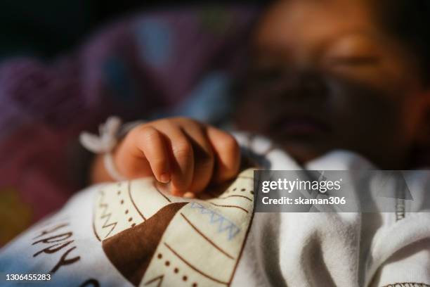 close up portrait  south east asian baby sleeping at home - child delivering stock-fotos und bilder