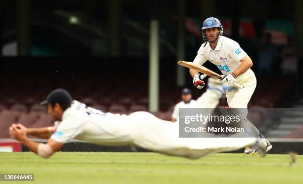 Simon Katich of the Blues watches on as a Bushranger fields during day four of the Shieffield Shield match between the New South Wales Blues and the...