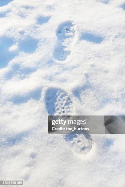 high angle view of shoe prints in snow - schuhabdruck stock-fotos und bilder