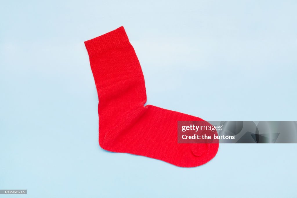 Still life of a red sock on blue background