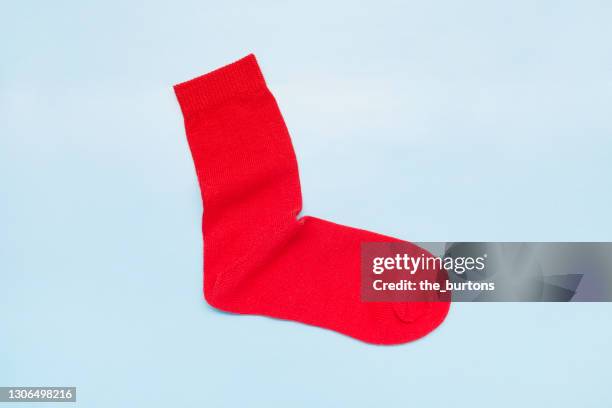 still life of a red sock on blue background - sock stock pictures, royalty-free photos & images