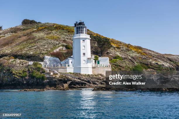 white lighthouse with rocks and green fields in idyllic location - falmouth stock-fotos und bilder