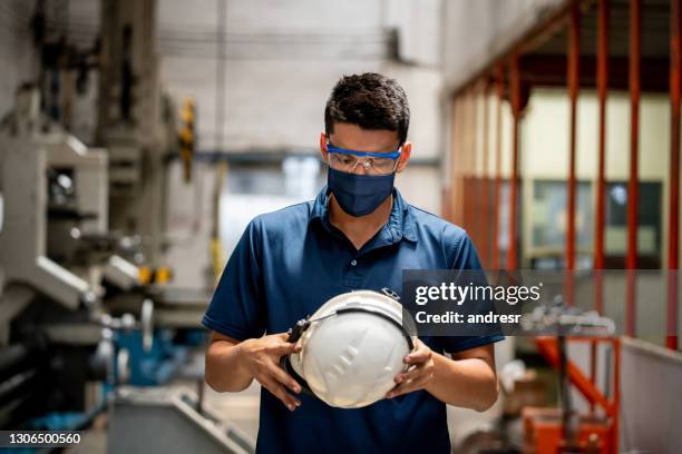 worker at a metallurgy factory wearing a facemask during the pandemic - metallurgical industry stock pictures, royalty-free photos & images