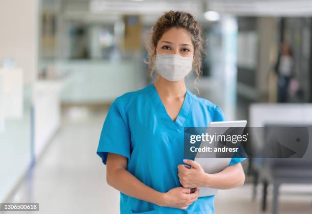 médico trabajando en el hospital durante la pandemia y usando una máscara facial - nurse with mask fotografías e imágenes de stock