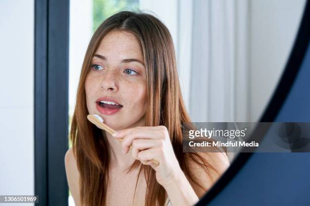 primer plano de una joven cepillándose los dientes en casa - brushing fotografías e imágenes de stock