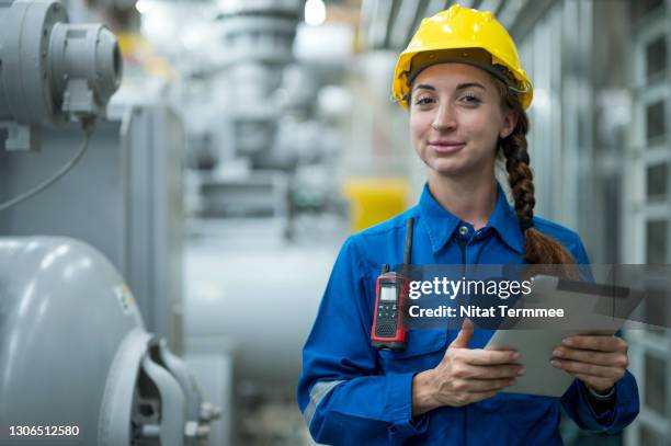 female industrial service engineer holding a digital tablet as her conducts a safety check in boiler room of food processing plant. - boiler engineer stockfoto's en -beelden