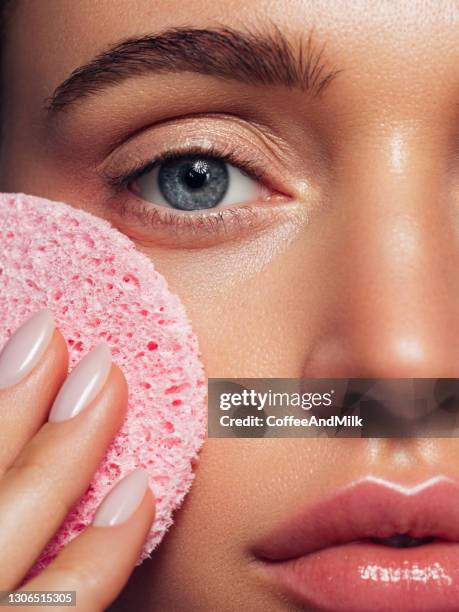 de jonge vrouw reinigt de huid natuurlijke spons - pores stockfoto's en -beelden