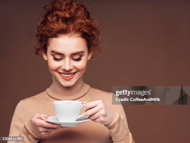 verticale d’une femme fraîche et belle, retenant une c.a. de café - women drinking coffee photos et images de collection