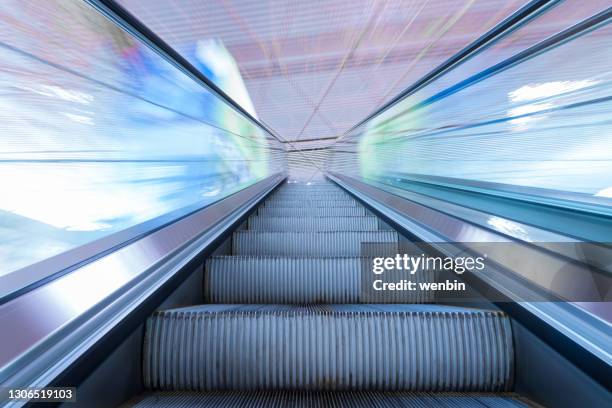 elevator running upward in airport - running up an escalator stock pictures, royalty-free photos & images