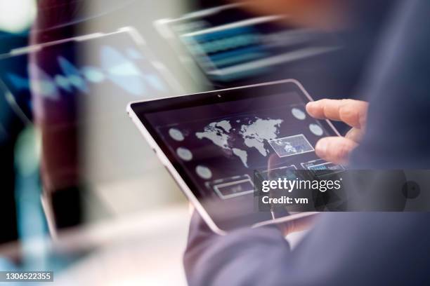unrecognizable businessman using a digital tablet - world map office stock pictures, royalty-free photos & images