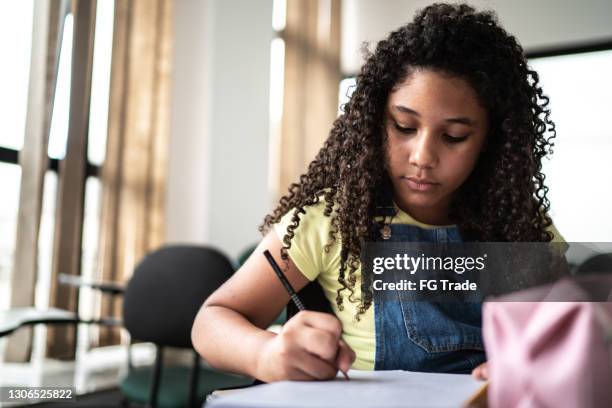 student writing in class at school - school routine stock pictures, royalty-free photos & images