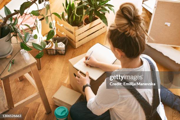 young woman moving in into new apartment - aufgabenliste stock-fotos und bilder